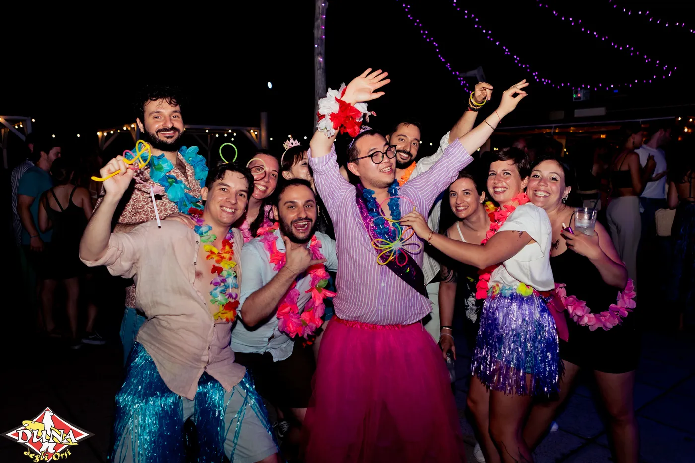 Serata a tema tropicale con ospiti in maschera e luci colorate